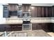 Kitchen with stainless steel appliances, dark cabinets, granite countertops, and a kitchen island at 11962 Autumn Fern Ln, Orlando, FL 32827