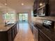 Kitchen featuring stainless steel appliances, dark cabinets, and granite countertops, offering a sleek cooking space at 11962 Autumn Fern Ln, Orlando, FL 32827