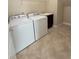 Practical laundry room with washer, dryer, storage, and a sink, offering convenience and functionality at 11962 Autumn Fern Ln, Orlando, FL 32827