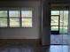 Bright living room featuring large windows offering serene neighborhood views and tiled floors at 11962 Autumn Fern Ln, Orlando, FL 32827