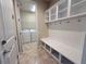 Mud room with a built-in bench and shelving, plus access to the laundry area at 11962 Autumn Fern Ln, Orlando, FL 32827