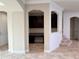Office nook featuring dark wood cabinetry, granite countertops, and tiled floors adjacent to a staircase at 11962 Autumn Fern Ln, Orlando, FL 32827