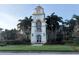 Community town center with clock tower, palm trees, manicured landscaping, and well-kept exterior at 11962 Autumn Fern Ln, Orlando, FL 32827