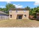 Backyard view of the property featuring a grassy area, mature trees, and the house's exterior at 126 Knights Hollow Dr, Apopka, FL 32712