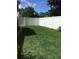 Green backyard area enclosed with a white vinyl fence and flourishing green grass at 1309 Harms Way, Port Orange, FL 32129