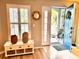 Bright foyer with white storage bench, shuttered window, decorative accents and a view into the home's interior at 1309 Harms Way, Port Orange, FL 32129