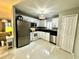 Bright kitchen with stainless steel appliances, white cabinets and modern lighting at 1309 Harms Way, Port Orange, FL 32129