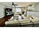 Comfortable living room featuring a large wicker sectional, ceiling fan, and hardwood floors at 1309 Harms Way, Port Orange, FL 32129
