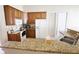 Well-lit kitchen features wood cabinets, granite counters, white appliances, and a stainless steel sink at 13157 Sw 35Th Cir, Ocala, FL 34473