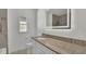Bright bathroom featuring white cabinets, granite counters, decorative mirror and tiled shower at 1326 W Concord St, Orlando, FL 32805