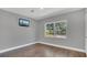 A simple bedroom with hardwood floors, gray walls, and a window providing natural light at 1326 W Concord St, Orlando, FL 32805