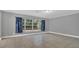 A living room with tile flooring, neutral gray walls, a large window and patterned curtains at 1326 W Concord St, Orlando, FL 32805