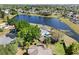 Aerial view of property on a lake, lush landscaping, and a screened pool at 134 Foggy Creek Ct, Davenport, FL 33837