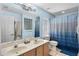 Bright bathroom featuring a double sink vanity, shower with blue tile, and updated fixtures at 134 Foggy Creek Ct, Davenport, FL 33837