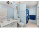 Well-lit bathroom with a single sink vanity, toilet, and a shower featuring blue tile at 134 Foggy Creek Ct, Davenport, FL 33837