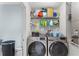 Organized laundry room with washer, dryer, shelving for storage, and ample space at 134 Foggy Creek Ct, Davenport, FL 33837