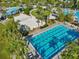 Expansive aerial view of multiple community pools, a volleyball court, and palm trees for resort style living at 13890 Sato Ave, Orlando, FL 32827
