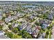 An aerial view shows a neighborhood featuring diverse homes, mature trees, and a serene lake at 13890 Sato Ave, Orlando, FL 32827
