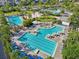 Bird's eye view of the community pools with lounge seating, a volleyball court, and palm trees for outdoor fun at 13890 Sato Ave, Orlando, FL 32827