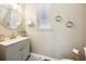 Charming half bathroom with a stylish vanity, gold fixtures, round mirror, and a window for natural light at 13890 Sato Ave, Orlando, FL 32827