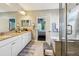 Bright main bathroom featuring double sinks, granite counters, and a separate shower with access to bedroom at 13890 Sato Ave, Orlando, FL 32827