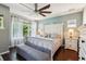 Comfortable main bedroom with a large window, wooden floors, a ceiling fan and stylish furnishings at 13890 Sato Ave, Orlando, FL 32827