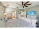 Bright main bedroom featuring a ceiling fan, hardwood floors, and an en-suite bathroom with a view at 13890 Sato Ave, Orlando, FL 32827