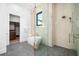 Bright bathroom featuring a soaking tub, glass shower, modern fixtures, and access to a walk-in closet at 1400 Nottingham St, Orlando, FL 32803