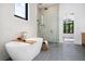 Bright bathroom with a soaking tub, glass shower, and stone tile floor, perfect for relaxation at 1400 Nottingham St, Orlando, FL 32803