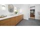 Bright bathroom featuring double sinks, wood cabinets, modern lighting, and access to a walk-in closet at 1400 Nottingham St, Orlando, FL 32803