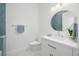 Chic bathroom with blue tiled accent wall, modern vanity, and a sleek, round mirror at 1400 Nottingham St, Orlando, FL 32803
