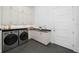 Laundry room with modern washer and dryer, custom cabinets, and hexagon tile flooring at 1400 Nottingham St, Orlando, FL 32803