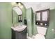 Green half bathroom featuring dark vanity and modern fixtures at 1415 Sherbourne St, Winter Garden, FL 34787