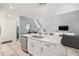View of the kitchen island with stainless steel dishwasher, white cabinets and view of the Gathering room at 1415 Sherbourne St, Winter Garden, FL 34787