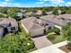 Aerial view of a home with a manicured lawn, lush landscaping, and a brick driveway at 1424 Palisades Lane, Deland, FL 32724