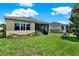 Beautifully landscaped backyard with a lush lawn, mature trees, and a view of the screened lanai at 1424 Palisades Lane, Deland, FL 32724