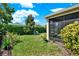 Landscaped backyard with a lush lawn, privacy hedge, and a screened patio, perfect for outdoor relaxation at 1424 Palisades Lane, Deland, FL 32724
