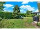 Manicured backyard featuring a lush lawn, mature trees, and privacy landscaping for outdoor enjoyment at 1424 Palisades Lane, Deland, FL 32724