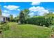 Well-maintained backyard with lush green lawn, privacy hedge, and a charming seating area at 1424 Palisades Lane, Deland, FL 32724