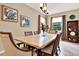 Formal dining room features a light wood table, seating for six, and windows with views of the outdoors at 1424 Palisades Lane, Deland, FL 32724