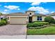 Charming single-Gathering home featuring a brick driveway, two-car garage, and manicured landscaping at 1424 Palisades Lane, Deland, FL 32724