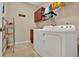 Well-organized laundry room featuring a washer, dryer, storage shelves, and upper cabinets for supplies at 1424 Palisades Lane, Deland, FL 32724