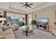 Cozy living room with large windows, comfortable seating, and a ceiling fan for optimal comfort and relaxation at 1424 Palisades Lane, Deland, FL 32724
