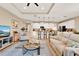 Bright living room shows open floorplan to kitchen, tray ceiling, comfortable seating, and large TV at 1424 Palisades Lane, Deland, FL 32724