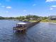 Picturesque pier stretches into serene waters, with homes dotting the distant shoreline at 14315 Hampshire Bay Cir, Winter Garden, FL 34787