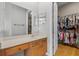 Bathroom vanity with dual mirrors and a walk in closet with ample storage at 14315 Hampshire Bay Cir, Winter Garden, FL 34787