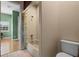 Bathroom with a tub and shower with neutral tile, and a leafy-patterned shower curtain at 14315 Hampshire Bay Cir, Winter Garden, FL 34787