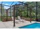 Covered lounging area with chairs by the pool and lush landscaping at 14315 Hampshire Bay Cir, Winter Garden, FL 34787
