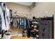 Well-organized walk-in closet with hanging rods, shelving, shoe rack, and a Winchester safe for secure storage at 14315 Hampshire Bay Cir, Winter Garden, FL 34787
