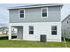 Rear exterior of a home with gray siding, white trim and a green backyard at 14647 Crestavista Dr, Clermont, FL 34714